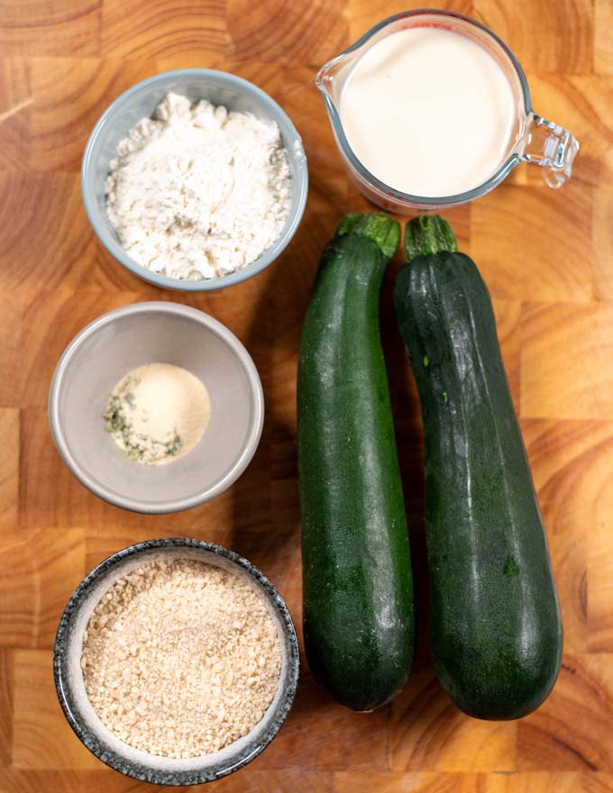 Ingredients needed to make Fried Zucchini are collected on a board.