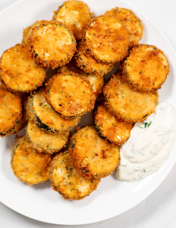 A plate with Fried Zucchini and dipping sauce.