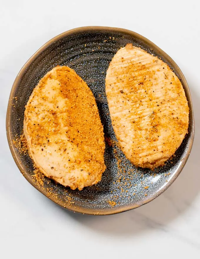 Chicken filets are seasoned with Cajun spice mix.