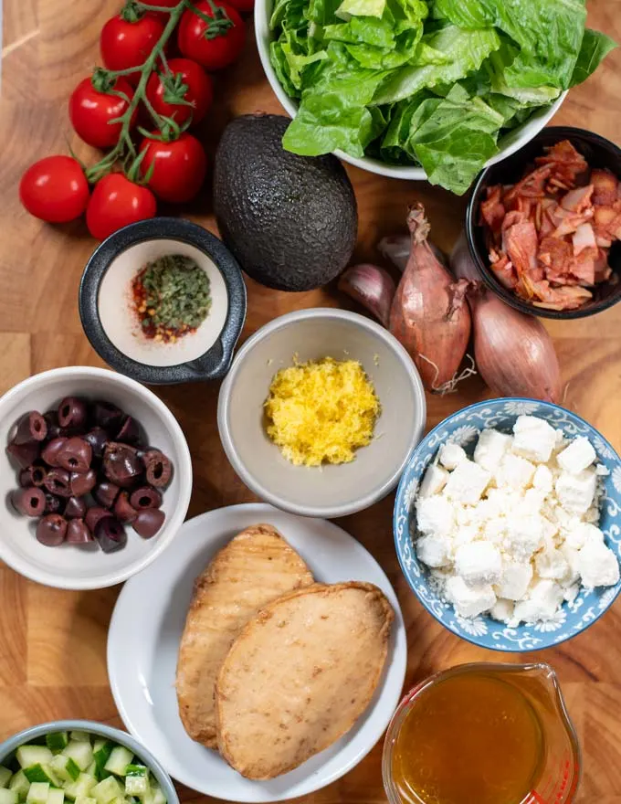 Ingredients needed to make Grilled Chicken Salad collected on a board.