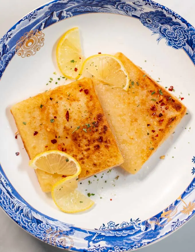 Additional herbs and chili flakes are used to garnish and season Saganaki.