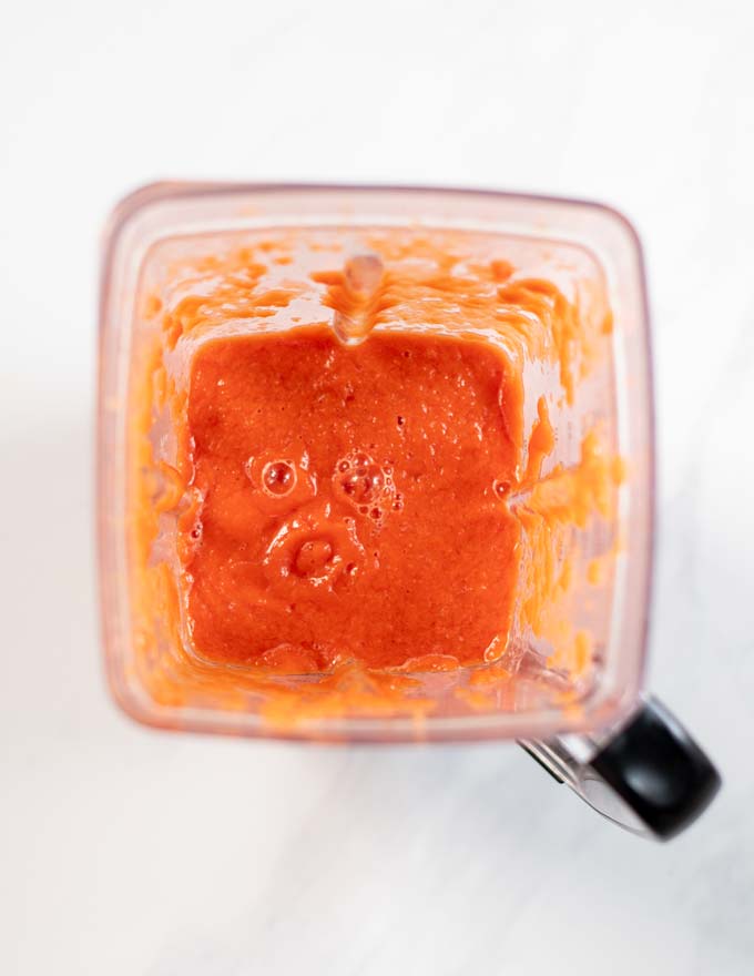 Top view into the bowl of a blender after processing the ingredients for the tomato broth.