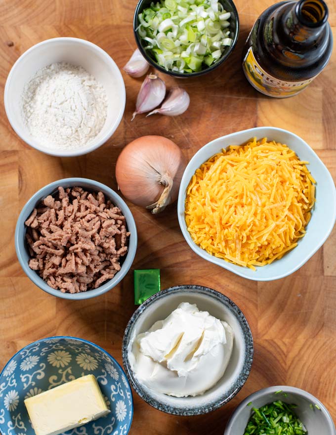 Ingredients needed for making Beer Cheese Soup are collected on a wooden board.