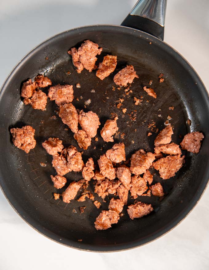 Burger Patties are fried in a pan.