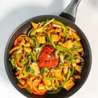 Fresh salsa is given into the pan with Chicken Fajitas.