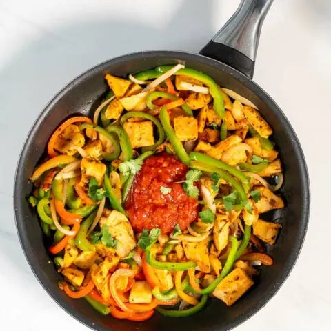 Fresh salsa is given into the pan with Chicken Fajitas.