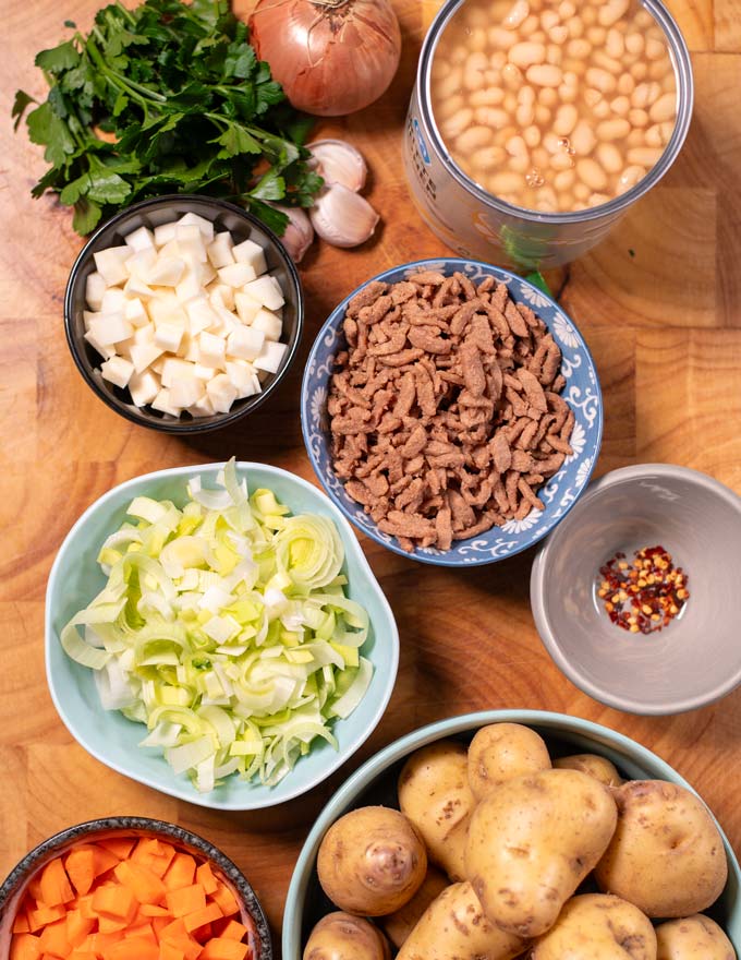 Ingredients needed to make White Bean Soup are collected on a board.