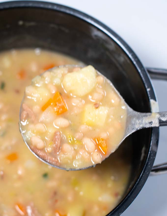 White Bean Soup is lifted from the pot.