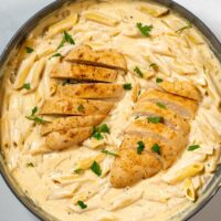 Two Cajun Chicken filets served on creamy Cajun Alfredo Pasta.