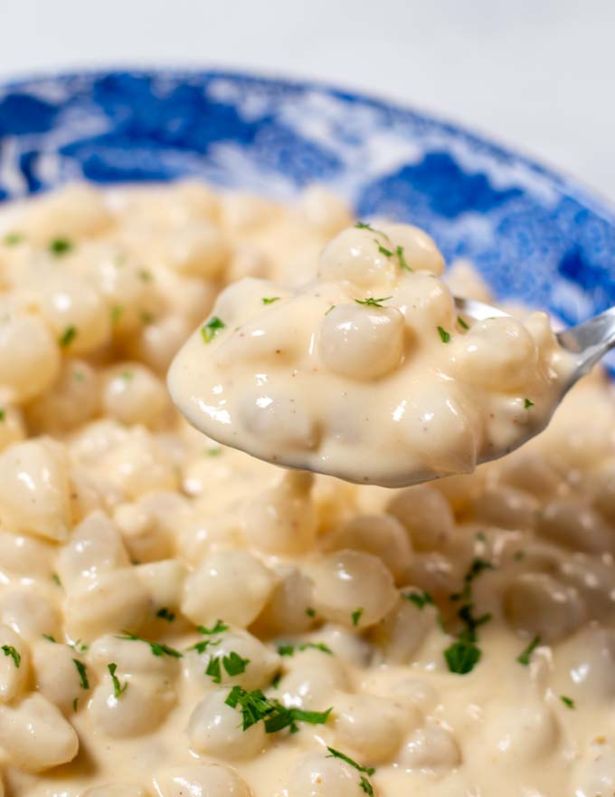 Closeup on a spoon full of Creamed Onions.