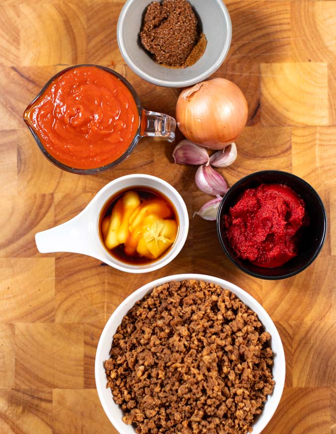 Ingredients needed to make Michigan Sauce are collected on a wooden board before preparation.