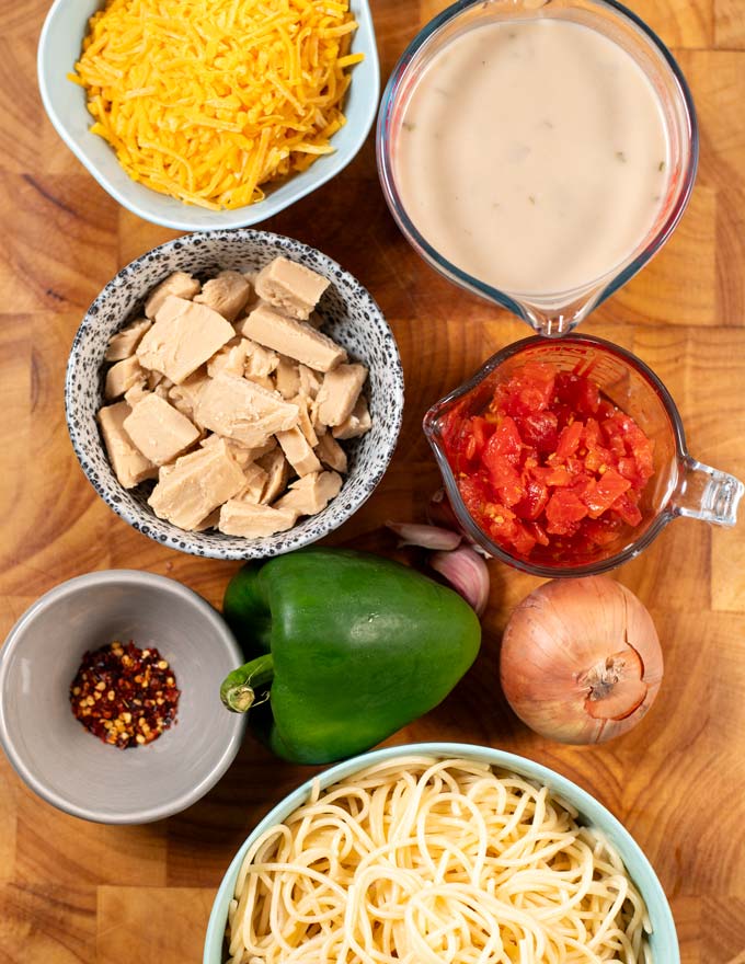 Ingredients needed for making Texas Chicken Spaghetti are collected on a wooden board.