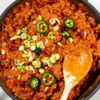 Texas Chili Beans are garnished with green onions an jalapeños.