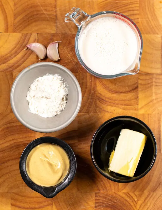 Ingredients needed to make Dijon Mustard Sauce collected on a board.