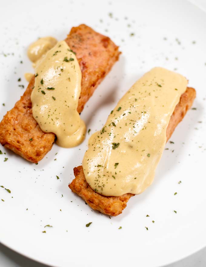 Closeup of a serving of plant-based salmon filets with Dijon Mustard Sauce.