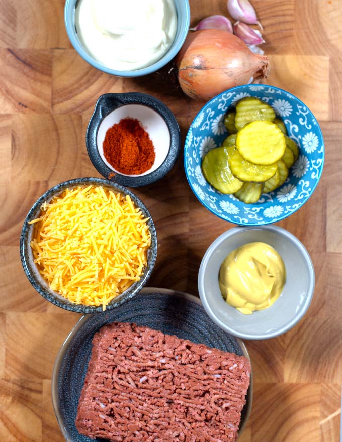 Ingredients needed to make Keto Big Mac Casserole are collected on a board.