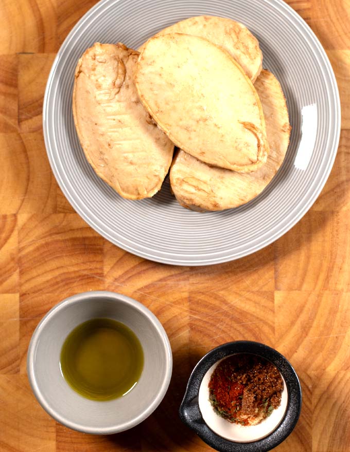 Ingredients needed for making Baked Chicken Tenders without breading are collected on a board.