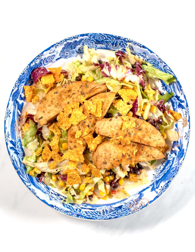 The Chicken Tenders Salad is garnished with broken tortilla ships.