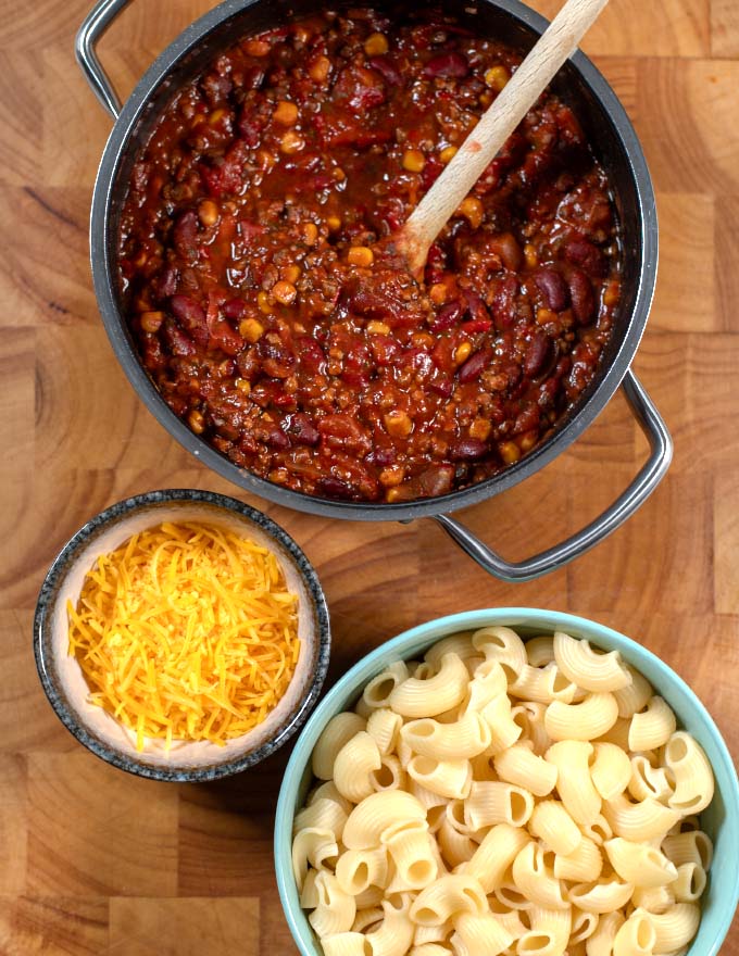 Ingredients needed to make Leftover Chili Mac collected on a board.