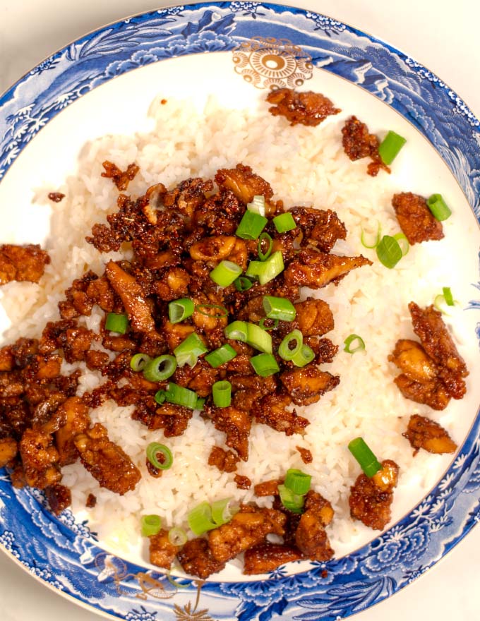 Cajun Stickt Chicken is cerved over rice and garnished with scallions.