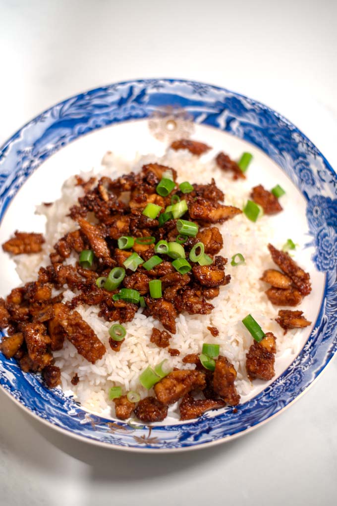 Sticky Chicken serving on a white plate with a blue pattern.