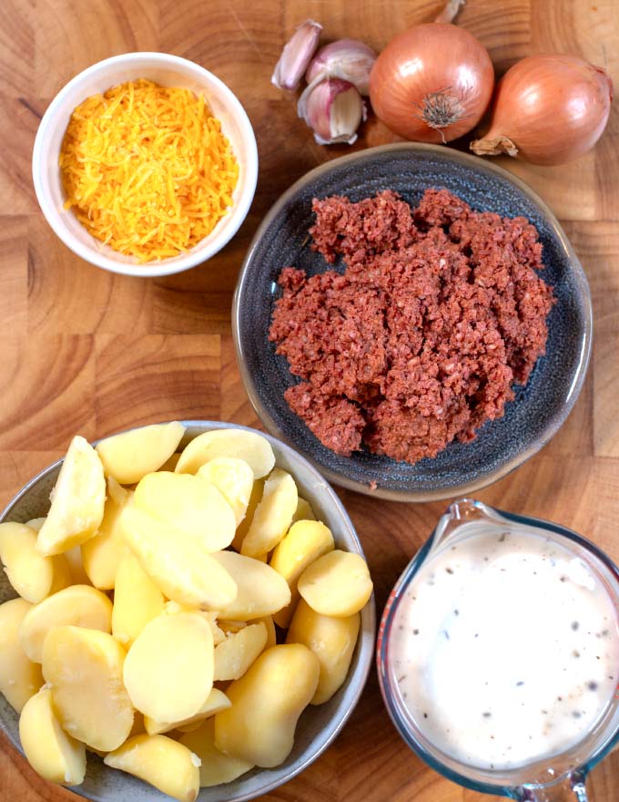 Ingredients needed to make Hamburger Potato Casserole are collected on a board.