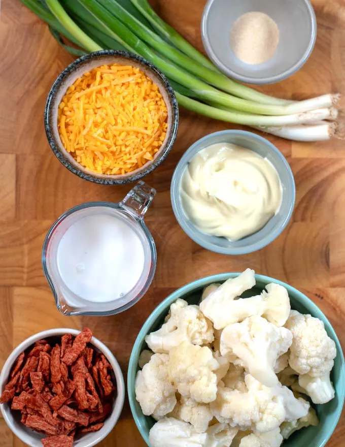 Ingredients needed to make Keto Cauliflower Cheese Casserole on a board.