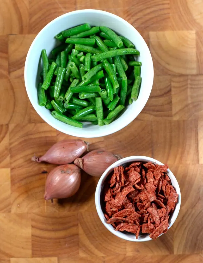 Ingredients needed to make Sautéed Green Beans collected on a board.