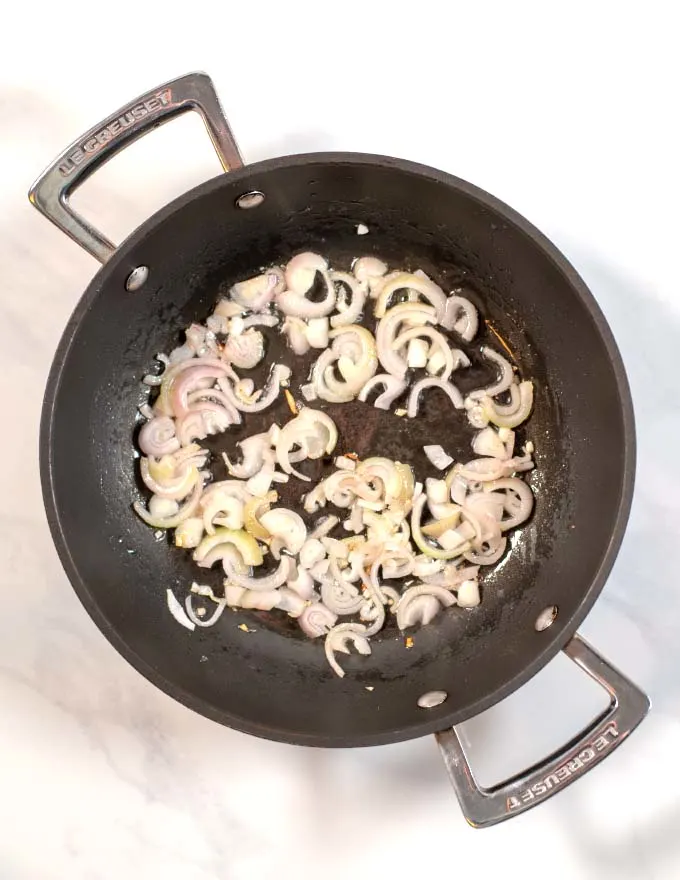 Top view of a saucepan with shallots.