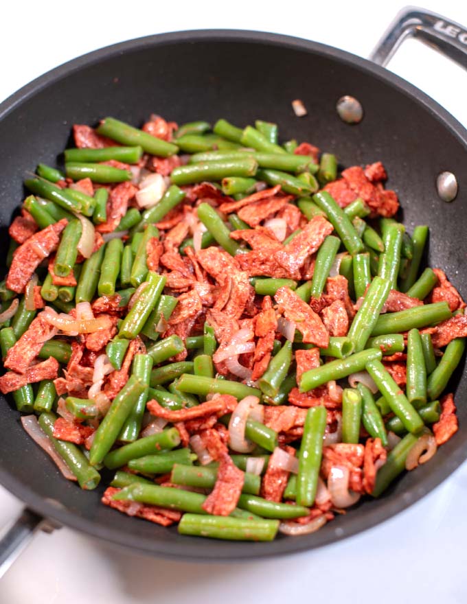 Closeup of a skillet with Sauteed Green Beans with bacon.