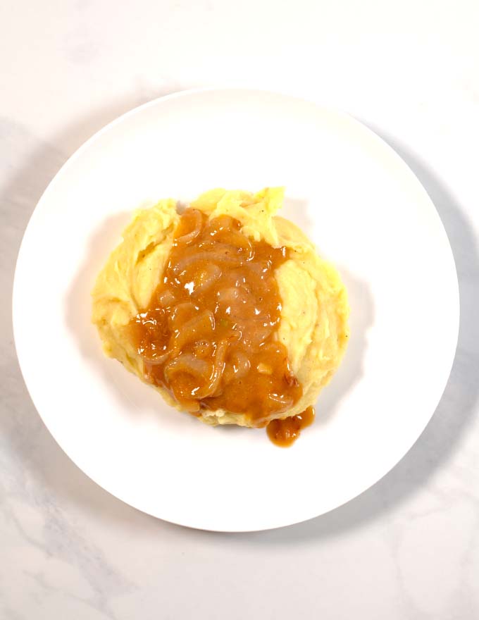 Top view of creamy mashed potatoes served with Southern Onion Gravy.
