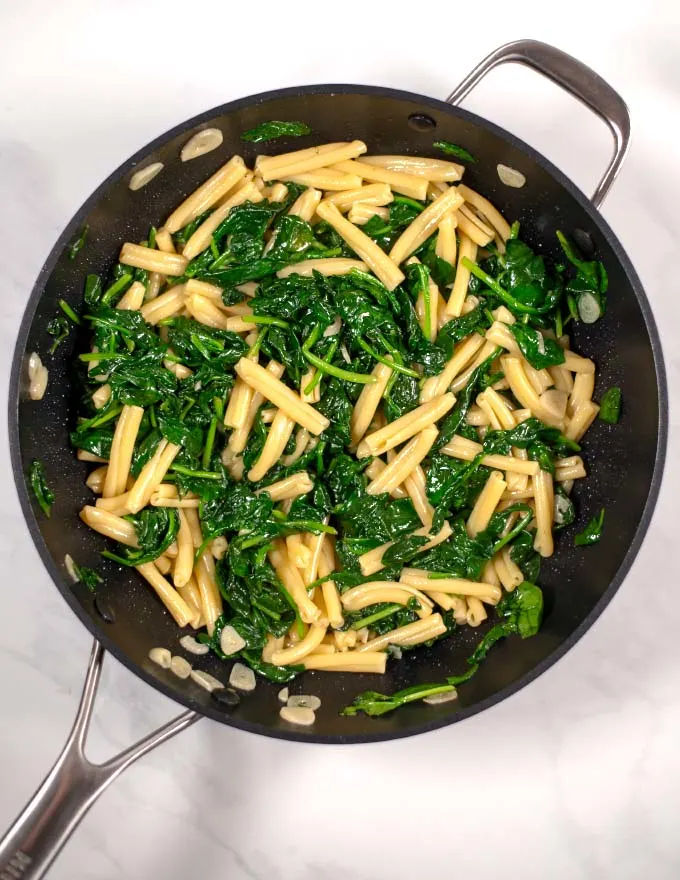 Top view of Casarecce Pasta with Spinach in a large pan.