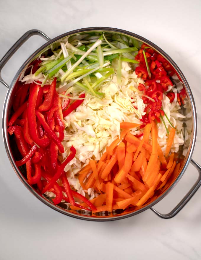 Top view of a large skillet with all ingredients for the Jamaican Cabbage.