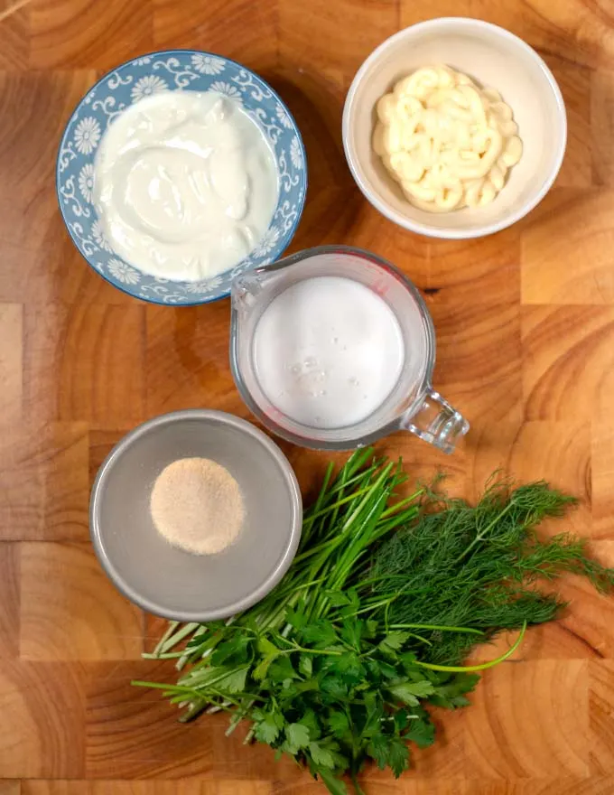 Ingredients needed to make Keto Ranch Dressing collected on a board.