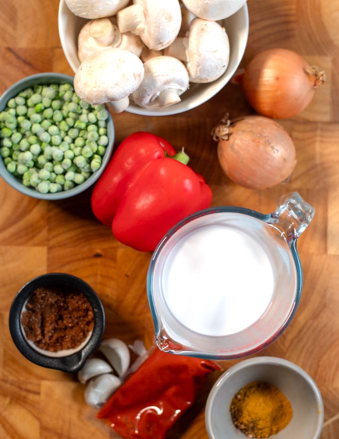 Ingredients needed to make Mushroom Curry collected on a wooden board. 