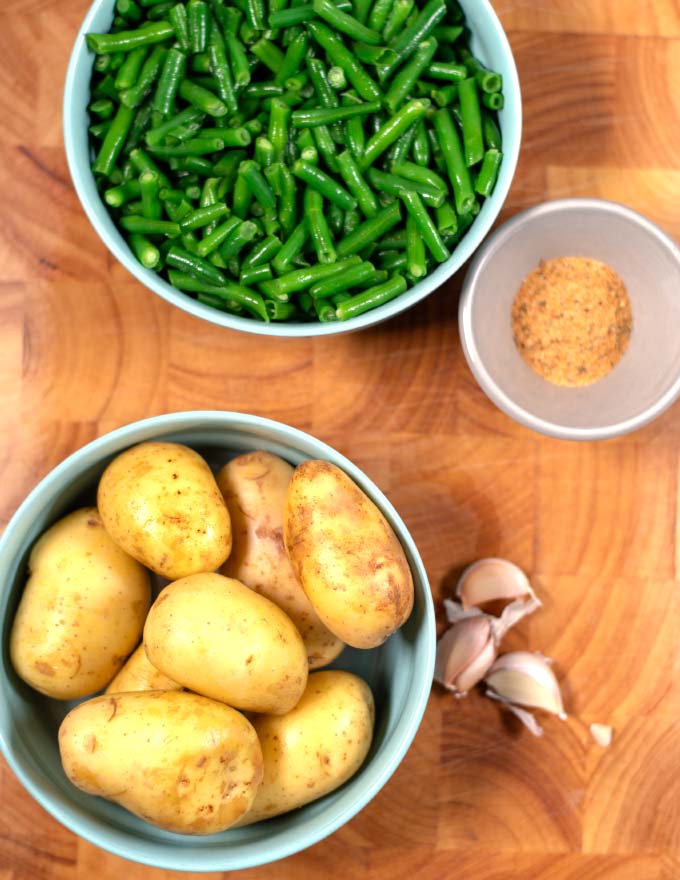 Ingredients needed to make Potatoes and Green Beans on a board.