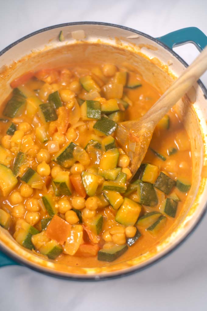 Top view of Zucchini Curry with a wooden spoon.