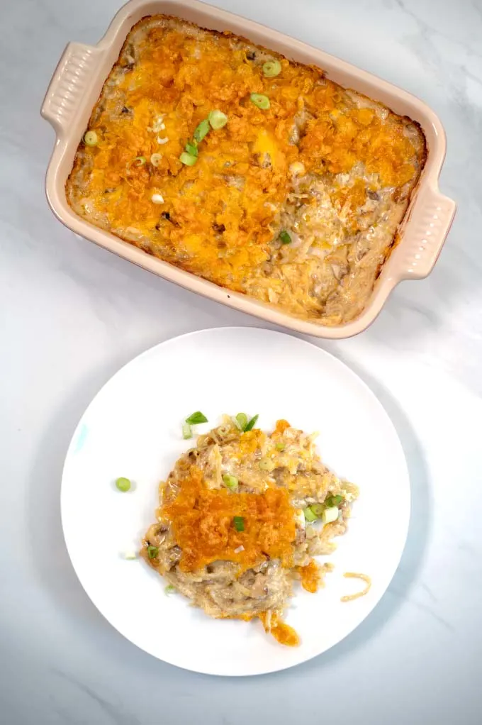 A portion of Texas Potatoes Casserole with the baking dish in the background.