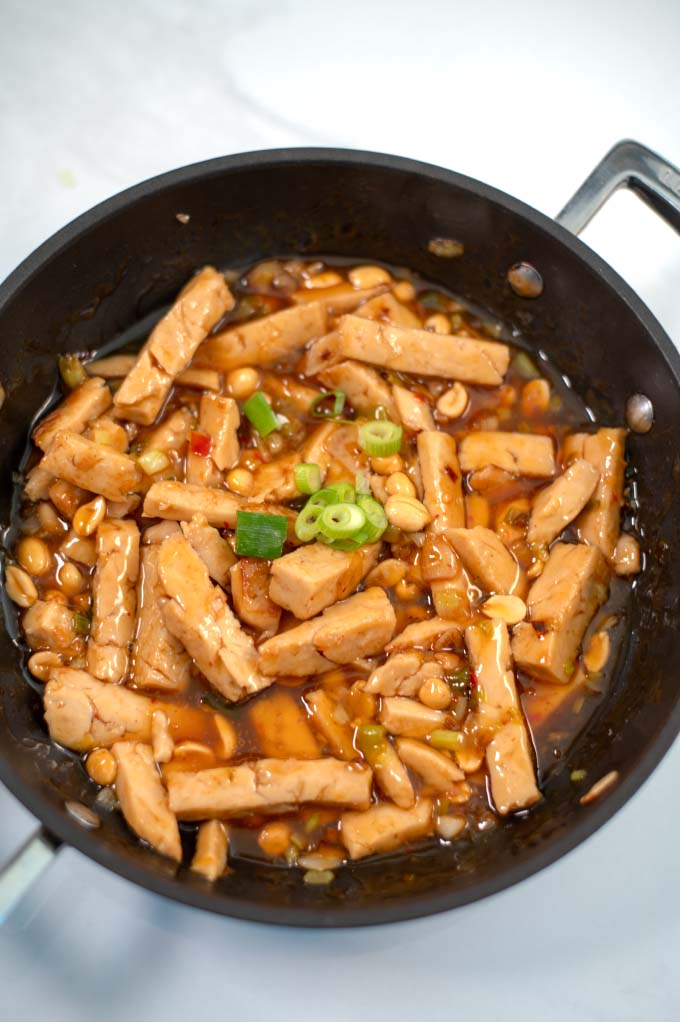 Ready Thai Chicken in a pan garnished with scallions.