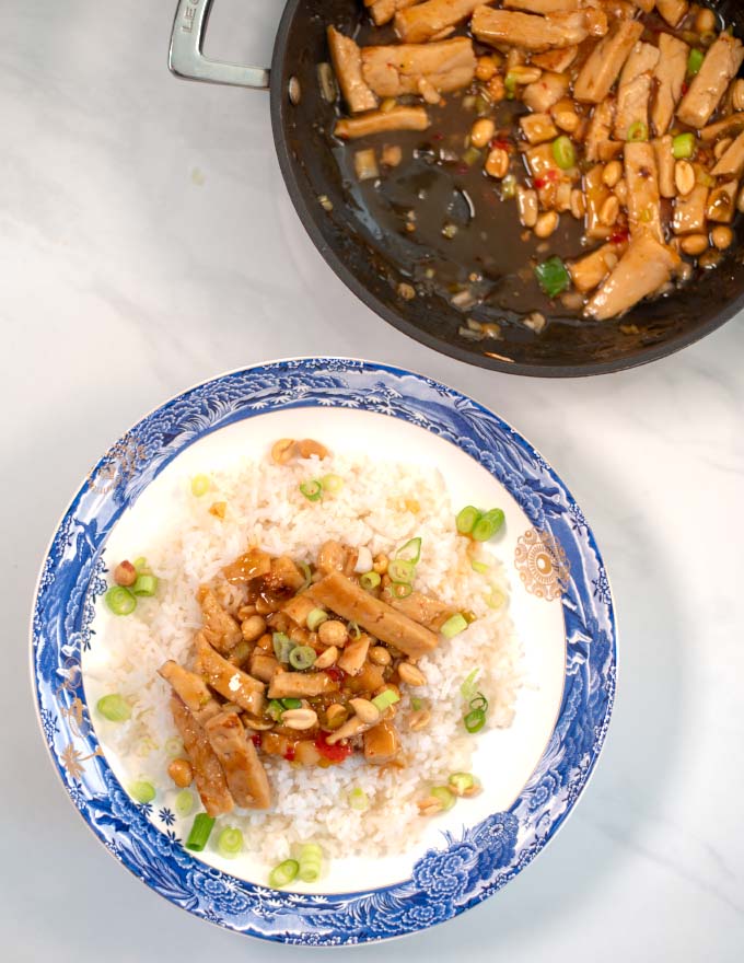 A serving of Thai Chicken over white rice with the pan in the background.