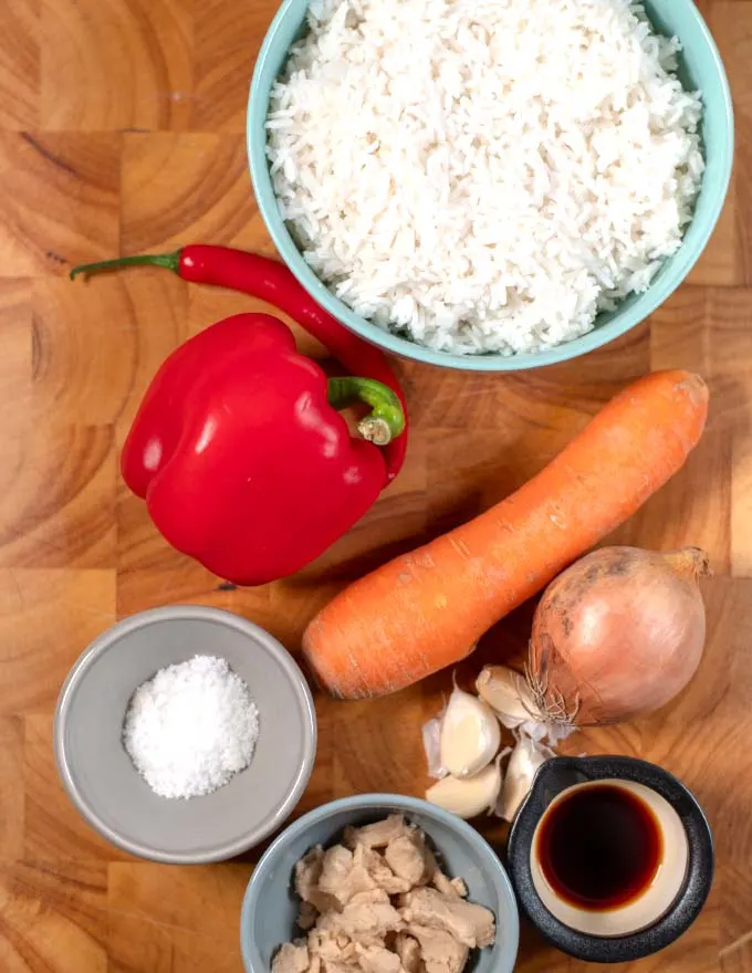 Ingredients needed to make Thai Fried Rice collected on a board.
