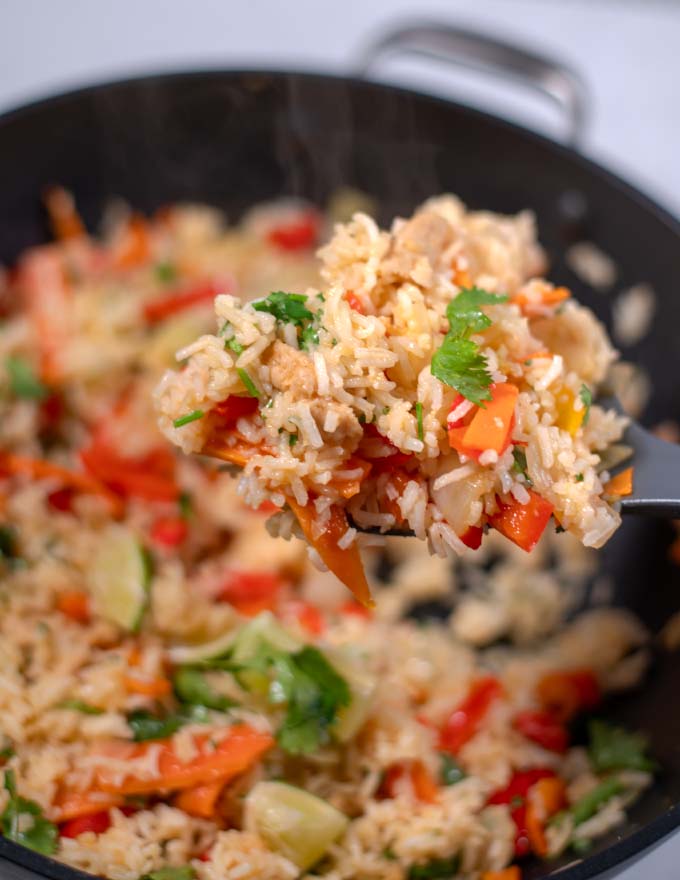 A large spoonful of Thai Fried Rice is lifted from the wok.