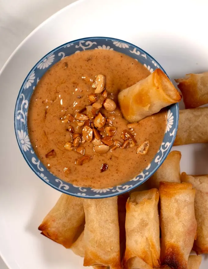Spring rolls dipped in sauce.