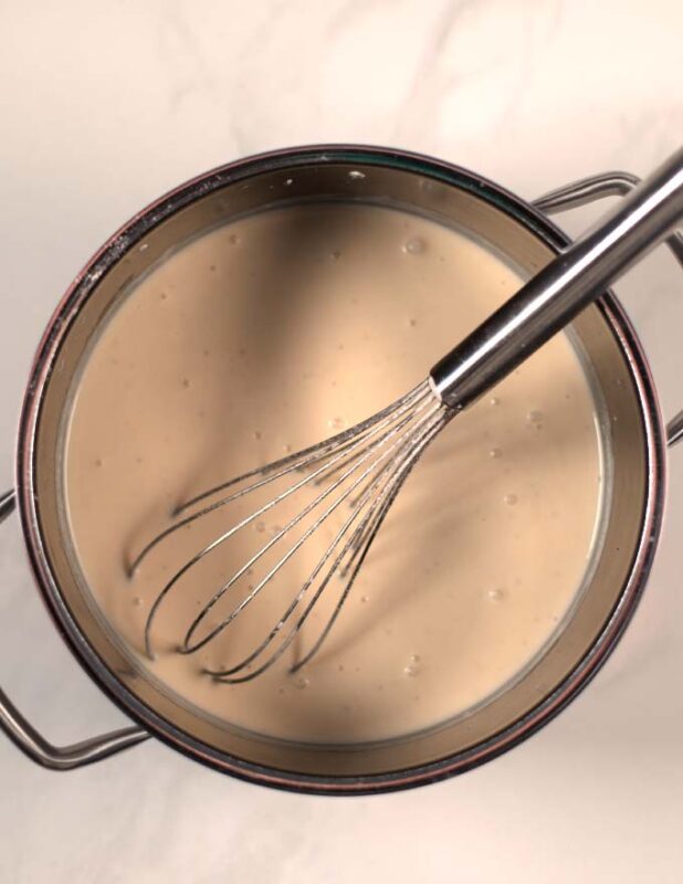 The white sauce for the Chicken Florentine Casserole in a pot.