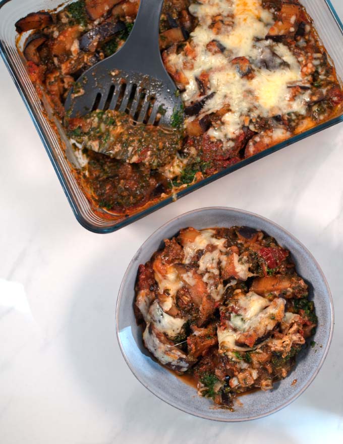 A serving of Eggplant Casserole with baking dish in the background.