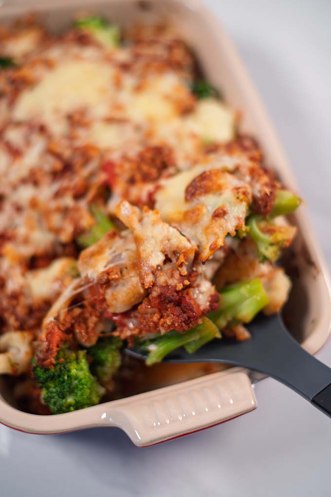 A large spoon lifts the casserole out of the baking dish.