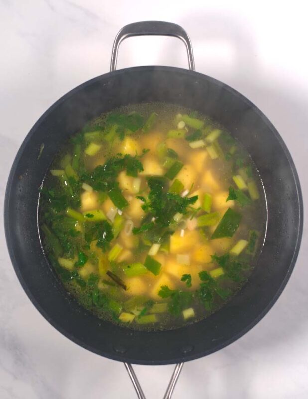 Broth is added to the pan of the Sancocho.