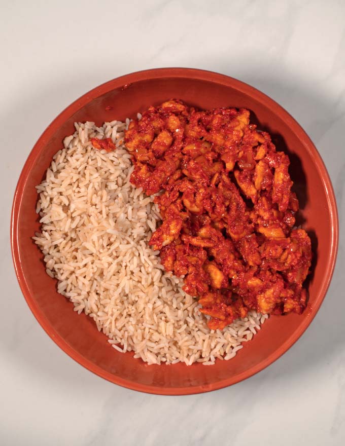 A serving of vegan chicken in Vindaloo Sauce with rice.