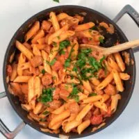 Hot Dog Pasta in a pan, garnished with fresh parsley.