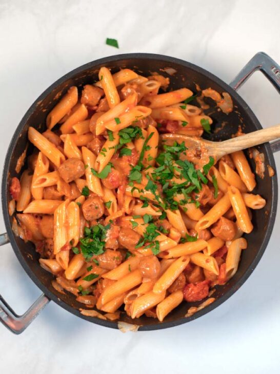 Hot Dog Pasta in a pan, garnished with fresh parsley.